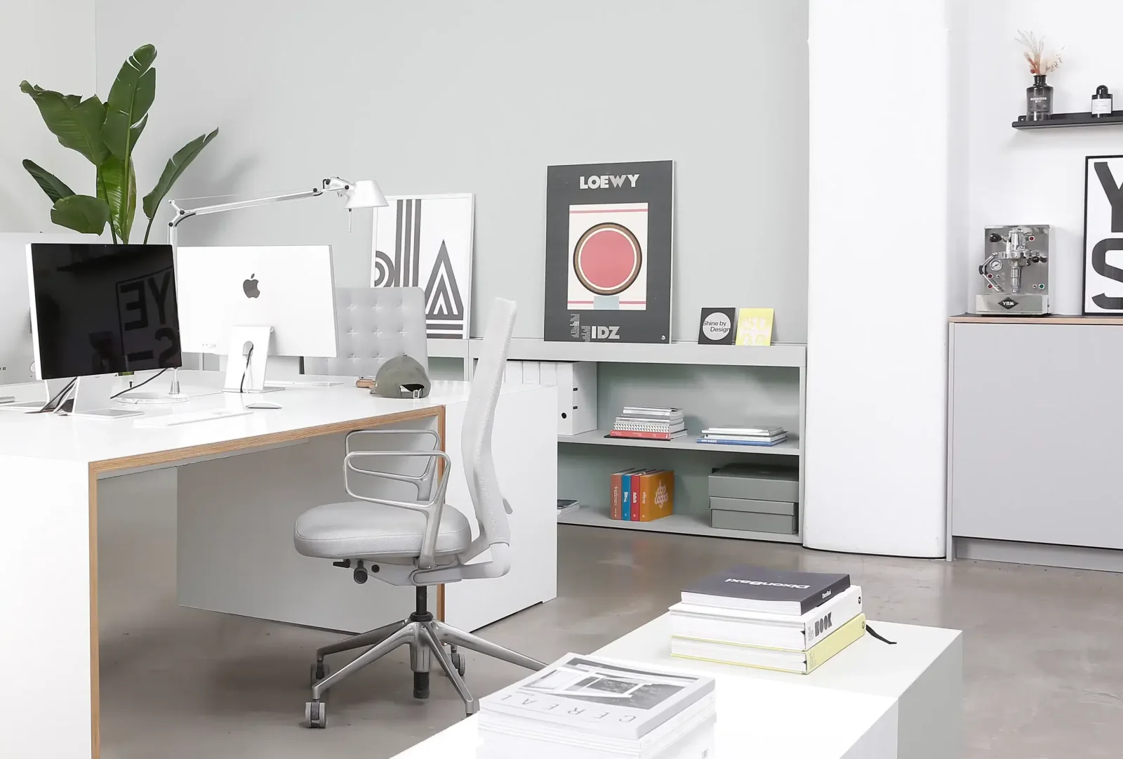 Arbeitsplatz im Nordpunkt Designstudio mit Bildschirmen, Plakaten und Fachbüchern